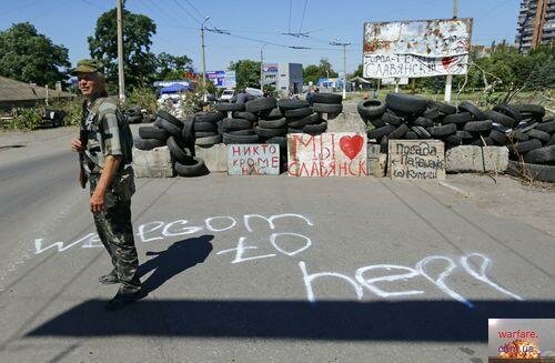 An armed pro-Russian separatist stands guard at check point in the Ukrainian eastern city of Slaviansk